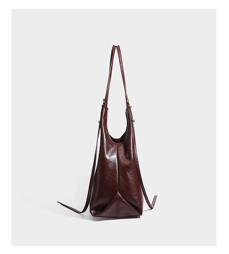 Lässige Hobo-Schultertasche mit offenem Oberteil in glänzender, geknautschter dunkelbrauner Lederoptik mit schmalem verstellbarem Riemen und goldfarbenem