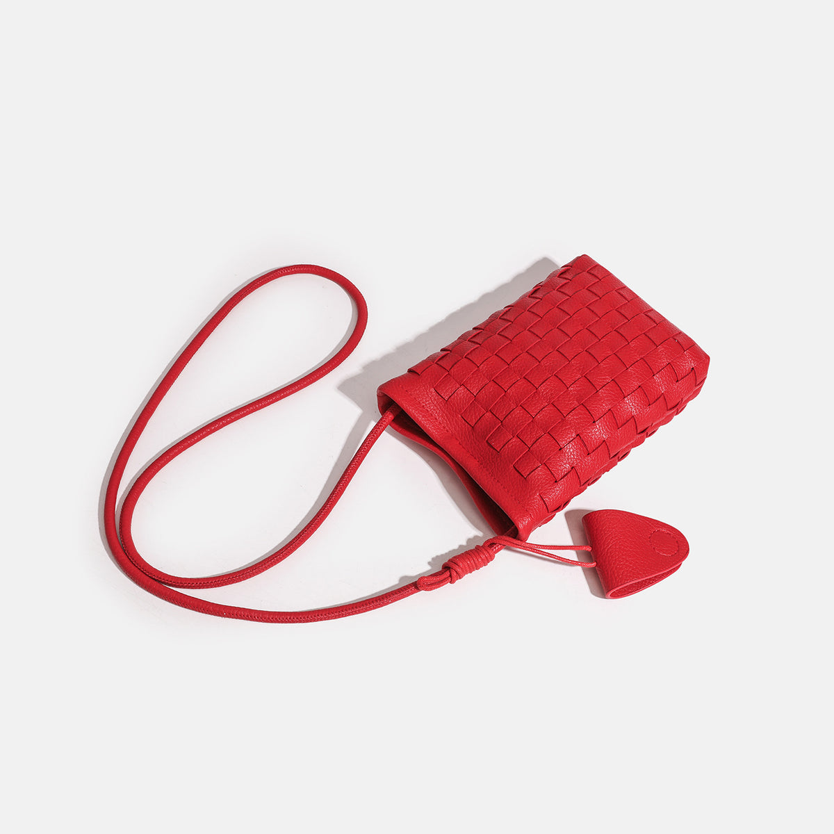 Mini woven square-pattern crossbody phone bag with long cord strap and front snap flap pocket in red textured leather-look