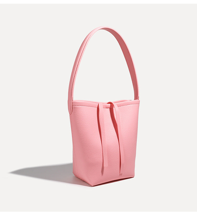 Mini tapered bucket bag in pebbled leather-look finish with front tie straps and single shoulder strap, detail view 18