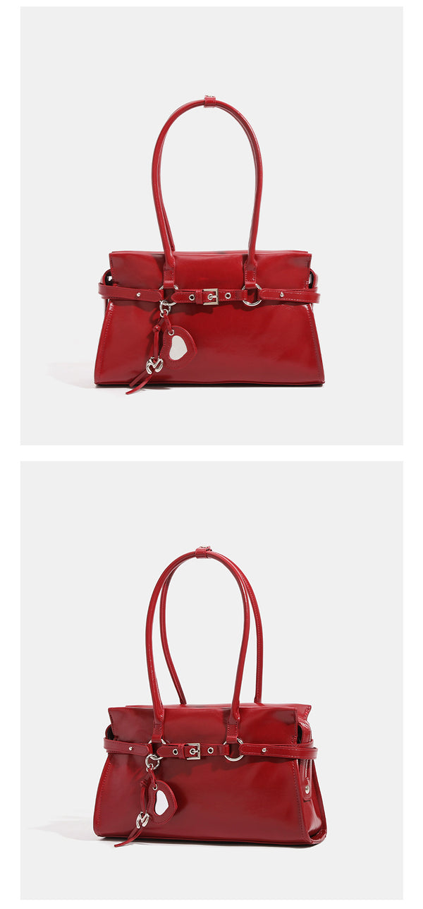 Strukturierte, glänzende trapezförmige Schultertasche mit zwei Tragegriffen, umlaufendem Riemen, silberfarbener Schnalle und hängendem