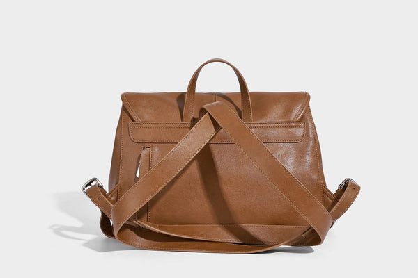 Structured tan leather-look flap backpack handbag with top handle, silver buckle hardware, and fold-over front closure