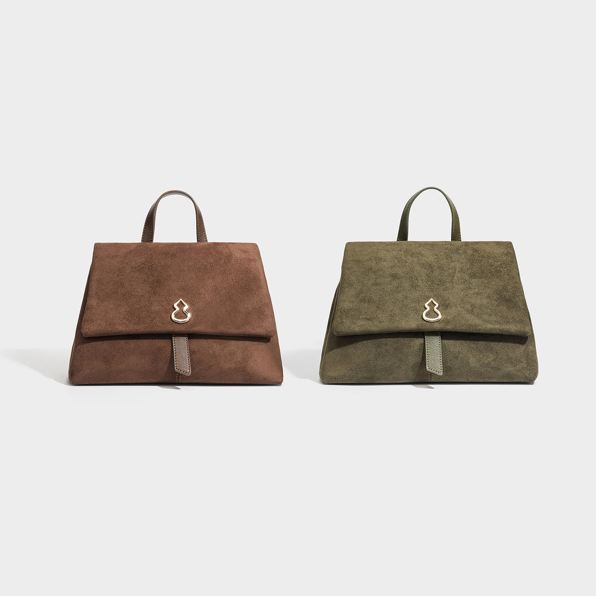 Structured matte suede-finish flap satchel bag with gold-tone emblem hardware, short top handle, and adjustable crossbody