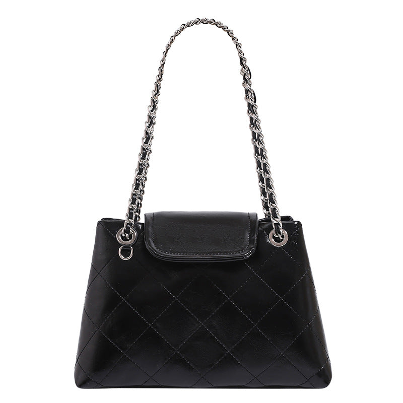 Quilted trapezoid shoulder bag with chain straps, flap closure, and ring hardware, detail view 5