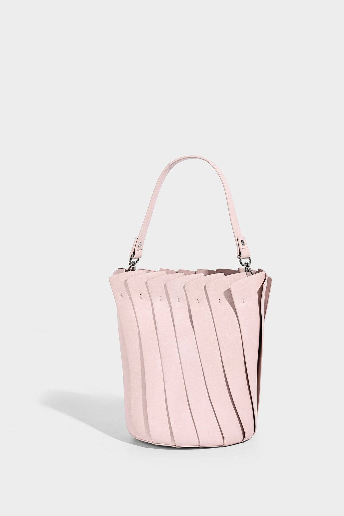 Structured pleated-panel bucket bag with curved top handle and detachable adjustable shoulder strap in smooth matte, detail