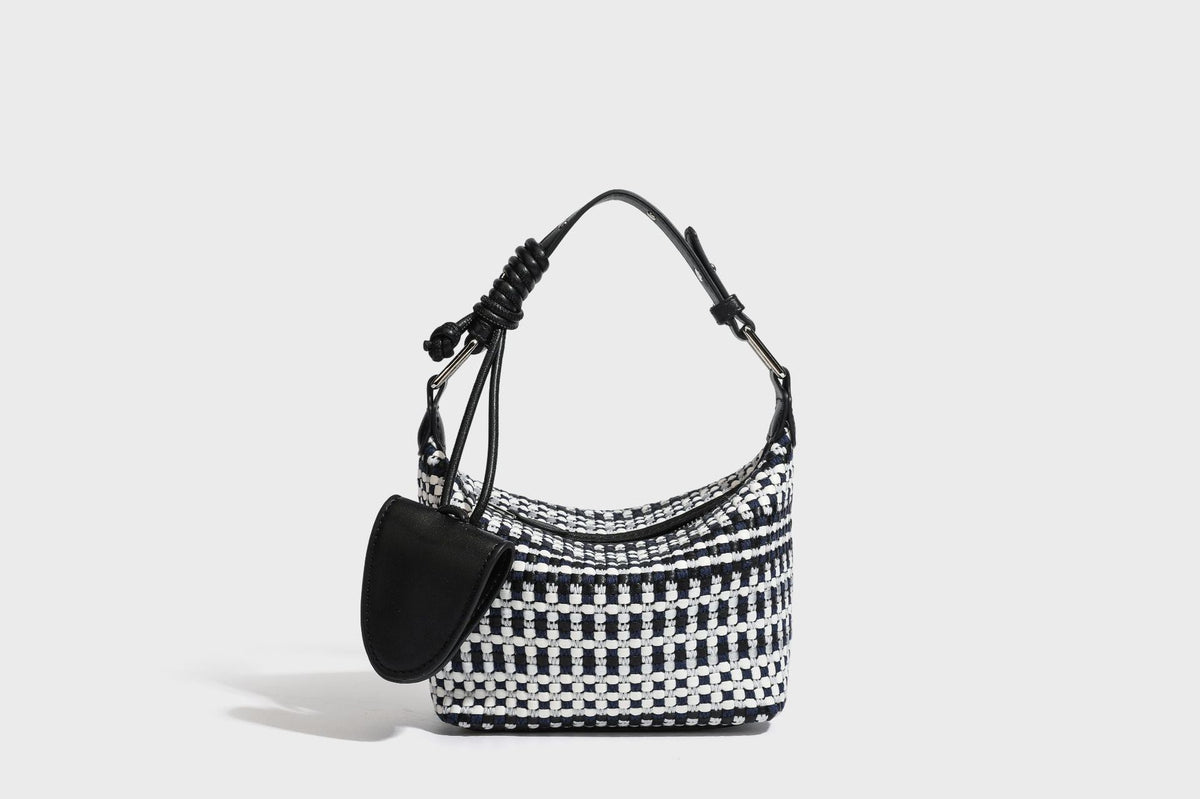 Small crescent shoulder bag in black-and-white woven textile with smooth black leather-look trim, zip-top closure, knotted