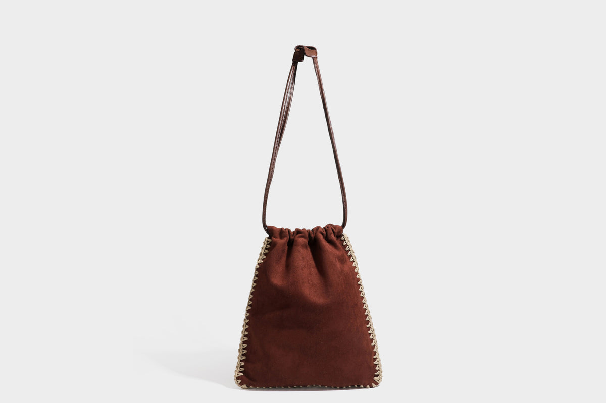 Matte suede-look drawstring bucket bag with cream braided woven edge trim and slim adjustable leather-look shoulder strap