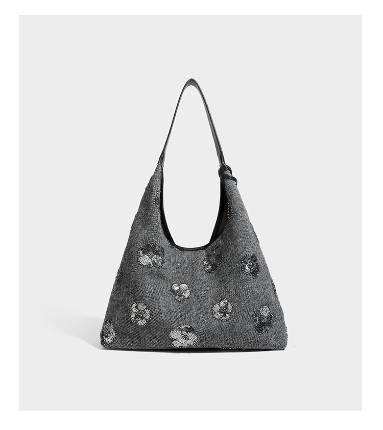 Lässig fallende, trapezförmige Schulter-Tote in Anthrazitgrau mit floralen Paillettenmotiven in Silber, Riemen in Lederoptik und herabhängendem Perlenbesatz
