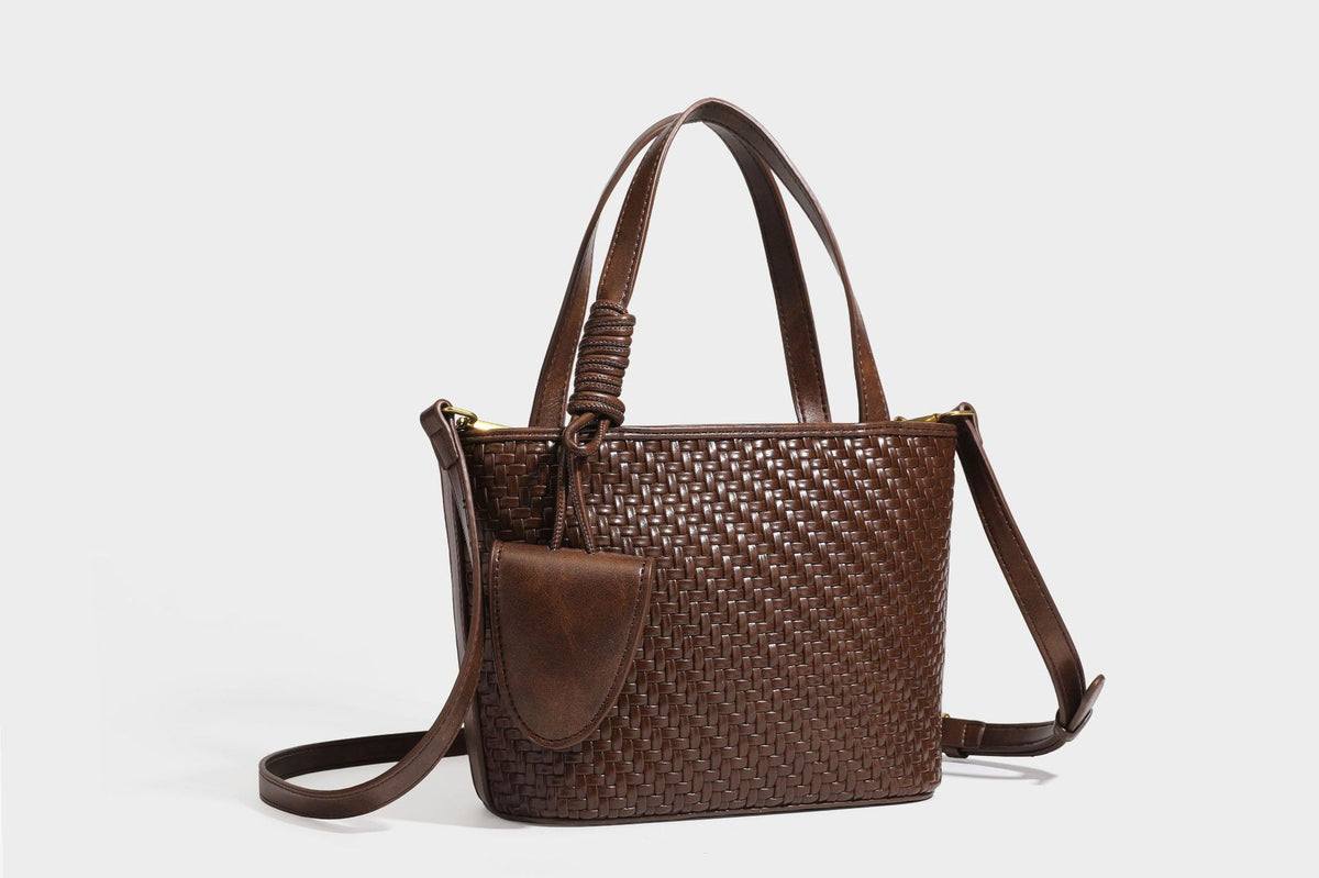 Strukturierte Tote Bag mit gewebter Oberfläche in Braun, goldfarbenen Metalldetails, seilumwickelten Tragegriffen, einer kleinen Fronttasche und weiteren Details