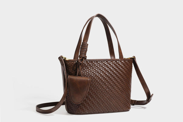 Strukturierte Tote Bag mit gewebter Oberfläche in Braun, goldfarbenen Metalldetails, seilumwickelten Tragegriffen, einer kleinen Fronttasche und weiteren Details