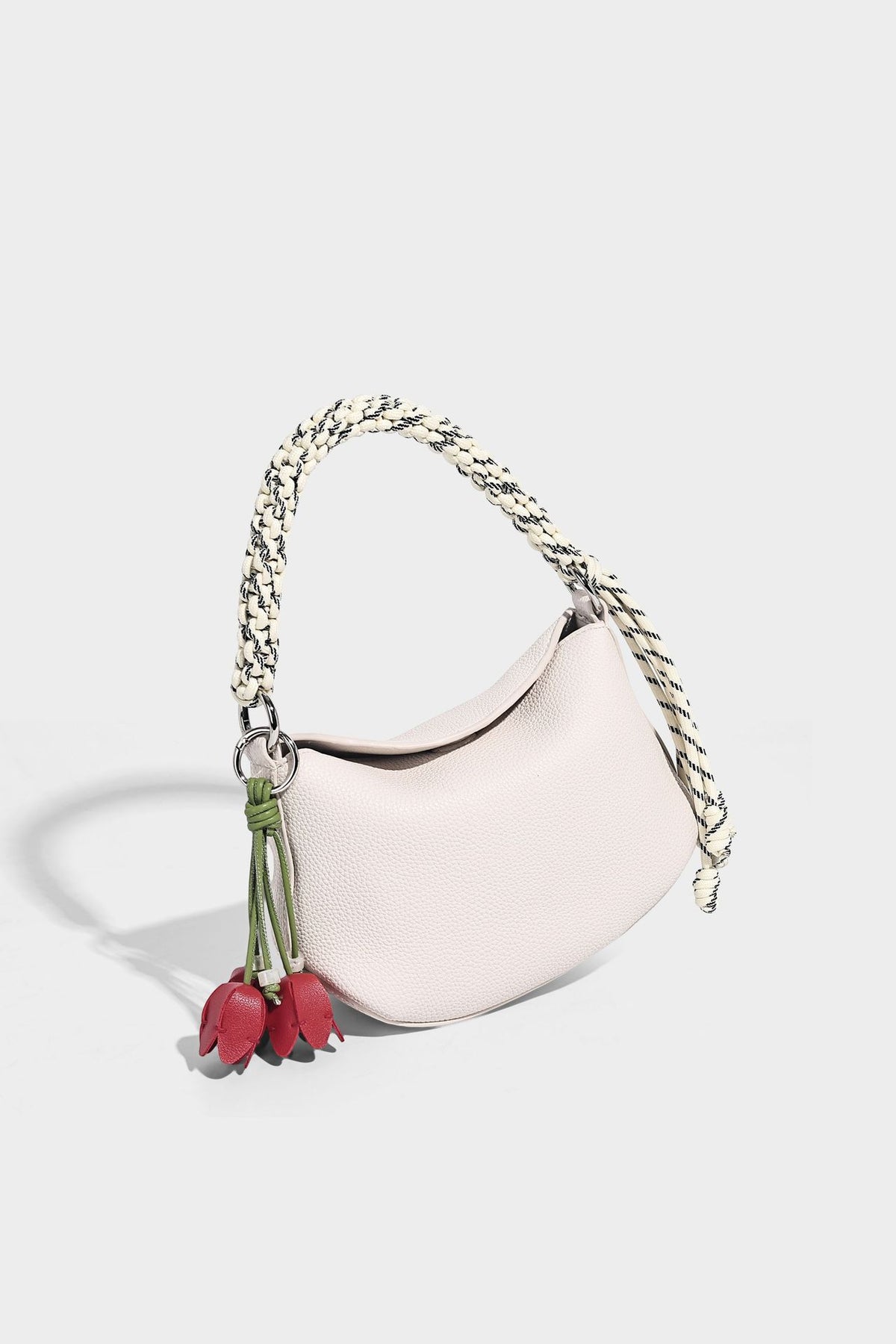 Small crescent half-moon bag in pebbled leather-look finish with braided top handle, silver-tone ring hardware, and, detail