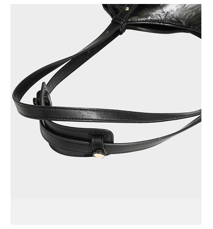 Große, glänzende Tote-Bag aus schwarzem Lederimitat mit geknitterter Optik, lässig fallender Trapezsilhouette, zwei Schulterriemen und goldfarbenen