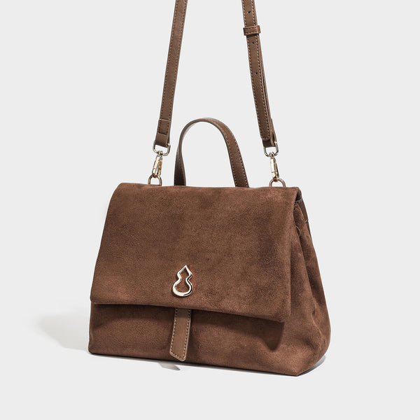 Strukturierte Klappentasche mit matter Velourslederoptik, goldfarbenen Emblembeschlägen, kurzem Tragegriff und verstellbarem Crossbody-