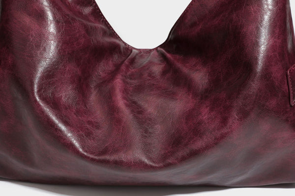 Lässige Hobo-Schultertasche in glänzender Lederoptik mit silberfarbenen Nieten, Riemendetail mit Schnalle und Reißverschluss oben