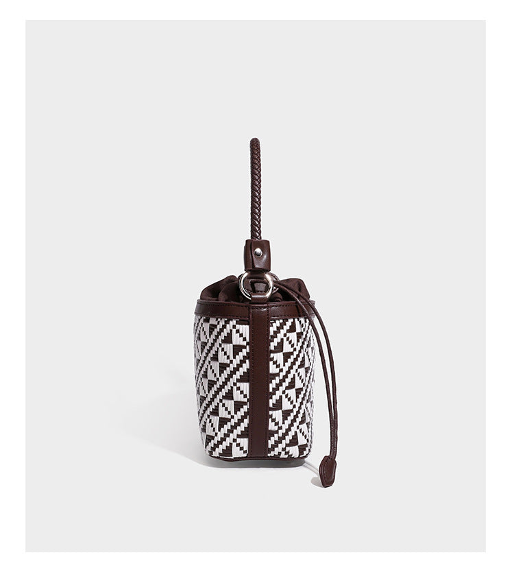 Kleine gewebte geometrische Bucket-Bag mit geflochtenem Henkel in Lederoptik und Kordelzugverschluss im zweifarbigen Muster aus Braun und Weiß