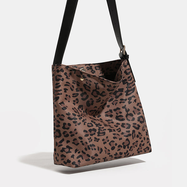 Brown and black leopard print canvas bucket bag with adjustable black leather-look shoulder strap and gold-tone hardware