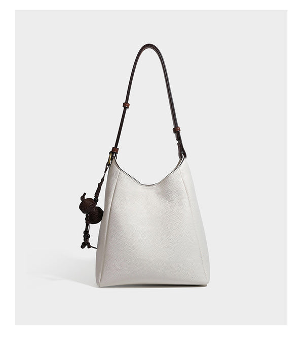 Hobo-Schultertasche in dunklem Espresso mit genarbter Oberfläche, warmen cognacfarbenen Details, verstellbarem schmalem Riemen, goldfarbenen Ringbeschlägen und geknotetem