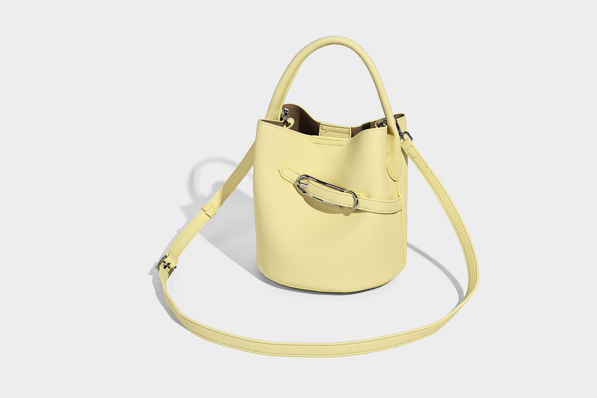 Mini pebbled leather-look bucket bag with front buckle strap, silver-tone hardware, top handle, and detachable shoulder