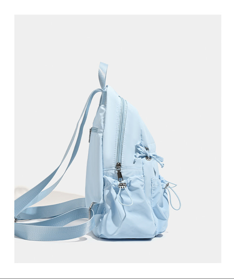 Puffy matte nylon mini backpack with drawcord gathered front pockets and silver-tone hardware, detail view 14