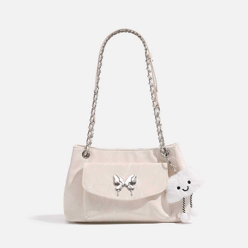 Soft rectangular glossy leather-look shoulder bag with silver chain strap, butterfly ornament on front flap pocket, and