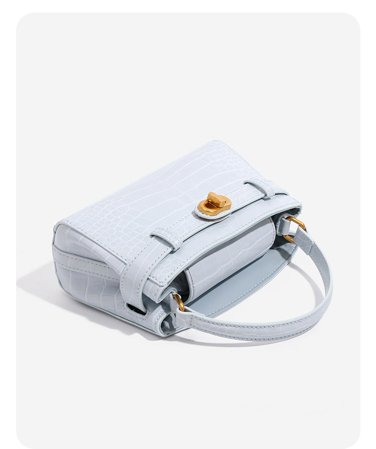 Small structured crocodile-embossed top-handle bag with gold-tone turn-lock closure and detachable shoulder strap, detail