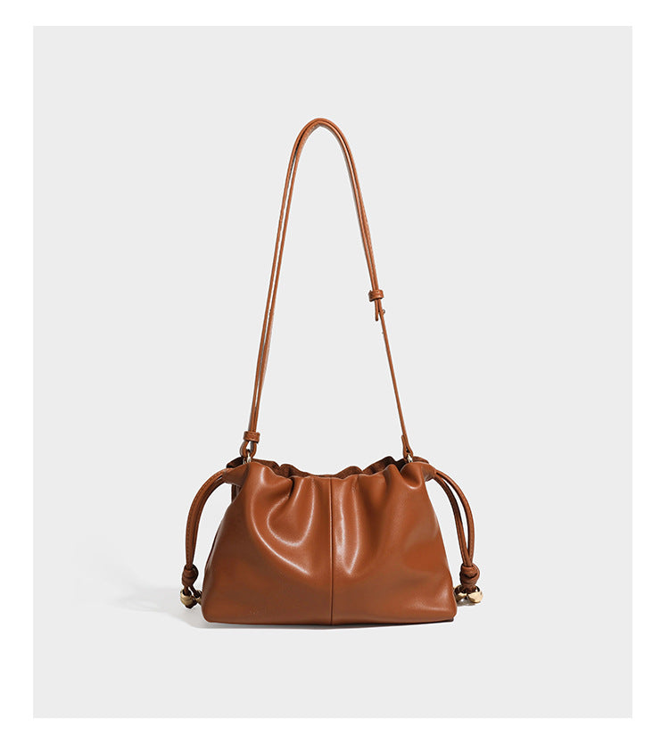 Suede-look drawstring shoulder bag in brown with smooth trim, knotted bead drawstring closure, slim adjustable strap, and
