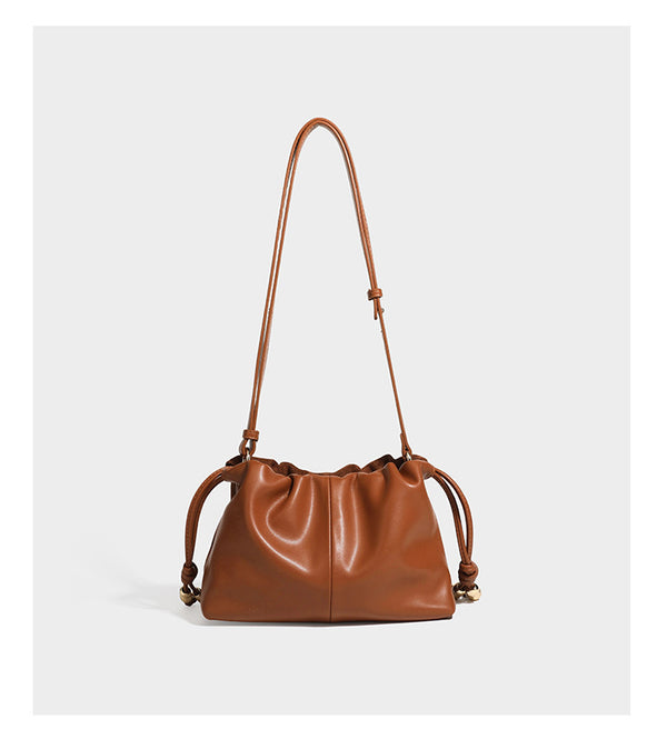 Suede-look drawstring shoulder bag in brown with smooth trim, knotted bead drawstring closure, slim adjustable strap, and