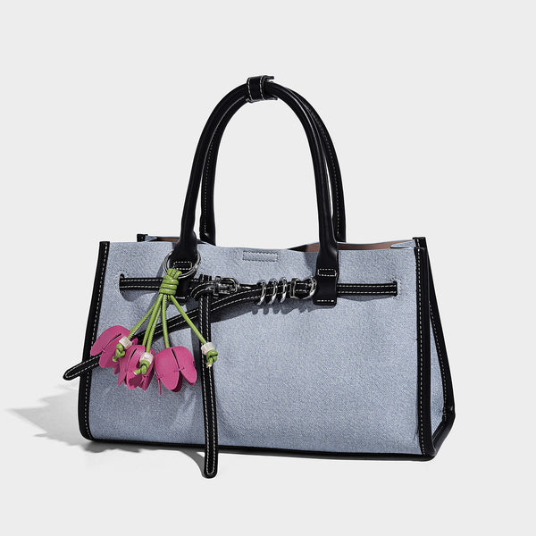 Structured rectangular tote satchel in denim-look fabric with dark trim, knotted front strap hardware, and detachable, detail