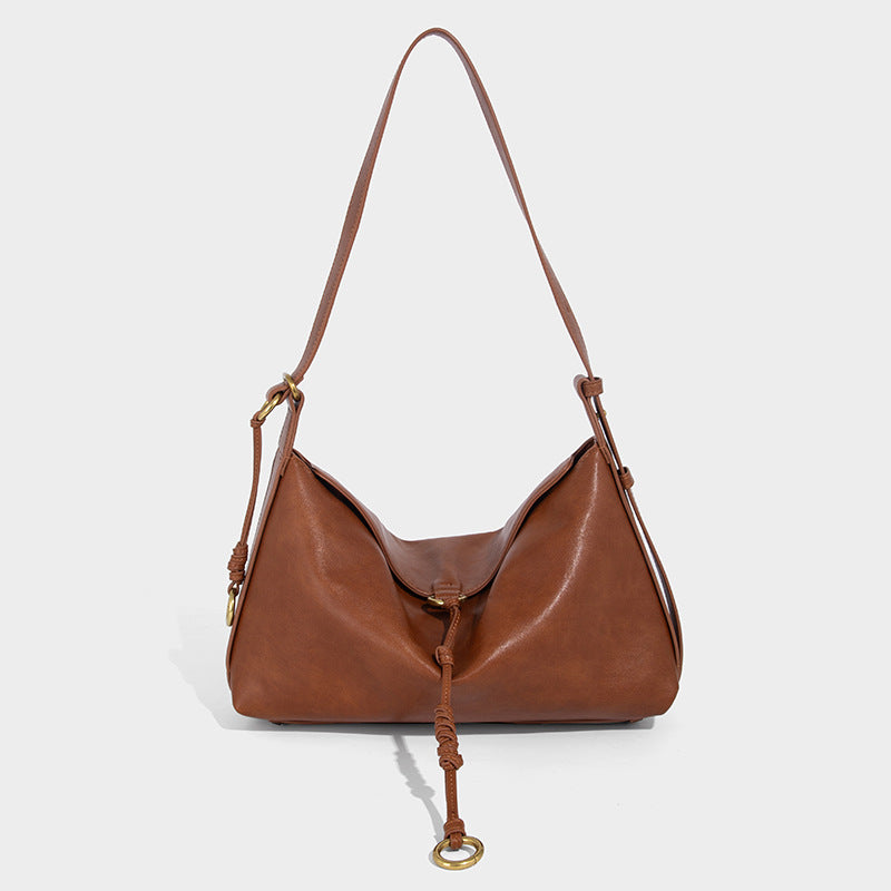 Slouchy brown leather-look shoulder bag with knotted drawcord tie closure, gold-tone ring hardware, and long adjustable
