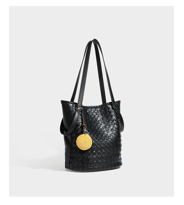 Brown embossed geometric woven leather-look bucket tote bag with dual shoulder straps, side snap hardware, and a round