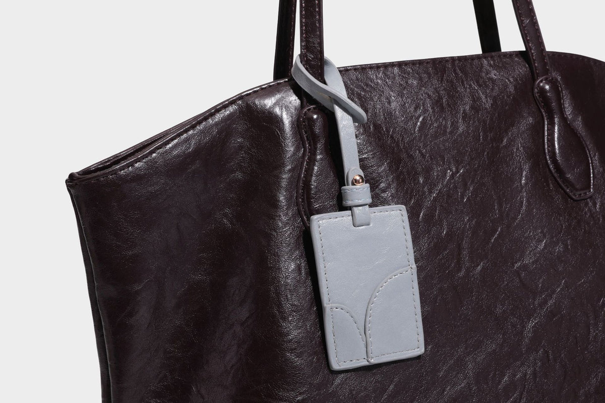 Übergroße, lässig fallende Tote-Bag aus glänzendem, geknittertem Lederimitat in dunklem Burgunderrot mit zwei langen Schulterriemen und kontrastierendem