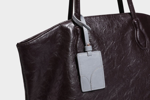 Übergroße, lässig fallende Tote-Bag aus glänzendem, geknittertem Lederimitat in dunklem Burgunderrot mit zwei langen Schulterriemen und kontrastierendem