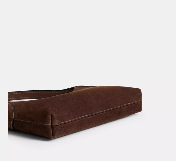 Slim crescent-silhouette shoulder bag in chocolate brown suede-look finish with contrast topstitching, top zip closure, thin