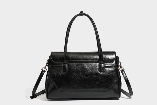 Structured glossy leather-look satchel bag with flap closure, gold-tone buckle accents, double top handles, detachable