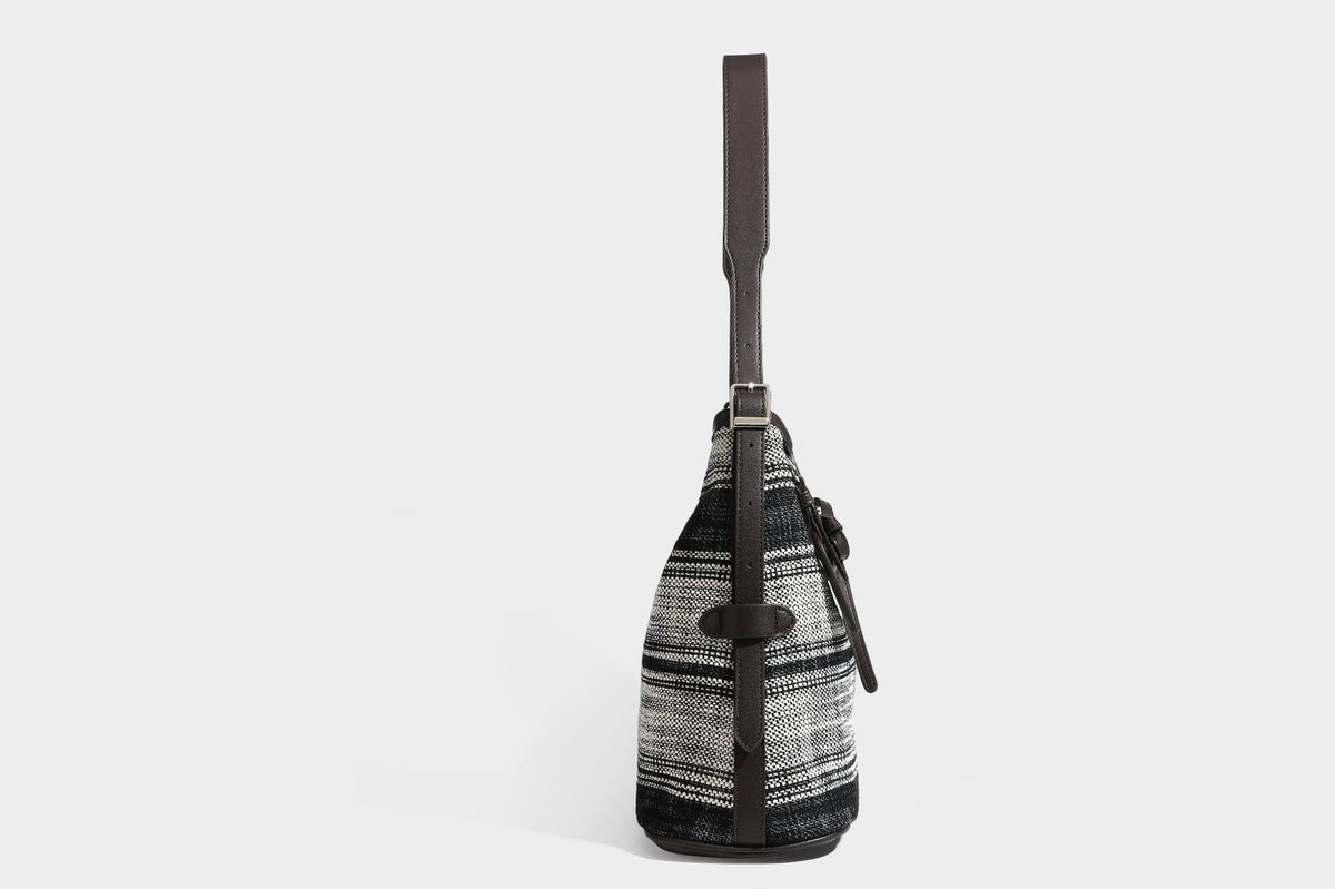 Schwarz-weiß karierte Hobo-Schultertasche aus gewebtem Material mit dunkelbrauner Einfassung in Lederoptik, Kordelzugverschluss und langem, verstellbarem
