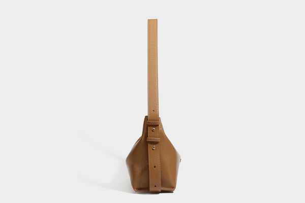 Lässig fallende Hobo-Schultertasche mit offenem Oberteil aus glänzender, karamellbrauner Lederoptik, mit Logo-Beschlägen in Goldoptik und langem, verstellbarem