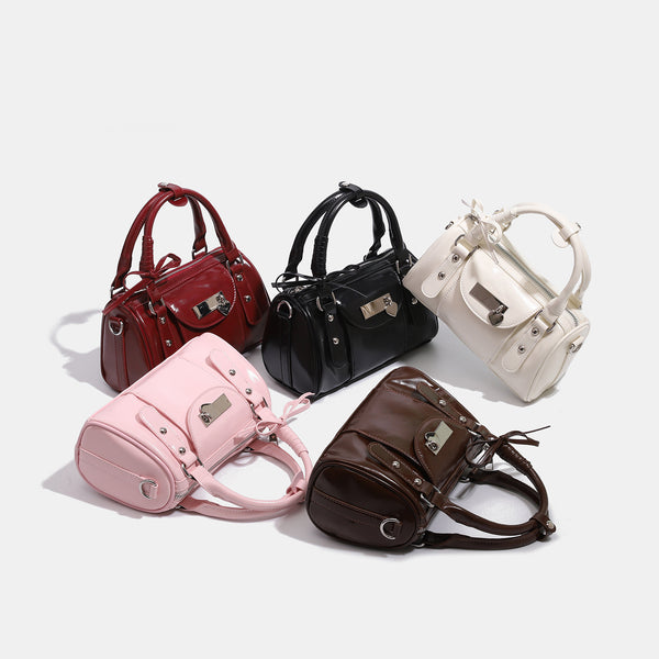 Kleine strukturierte Henkeltasche mit glänzender Oberfläche, zwei Tragegriffen, aufgesetzter Fronttasche, herzförmigem Verschlussanhänger und silberfarbenem