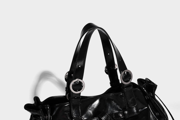 Glossy patent-look slouchy tote bag with ruched drawstring sides, dual top handles, silver ring hardware, and detachable