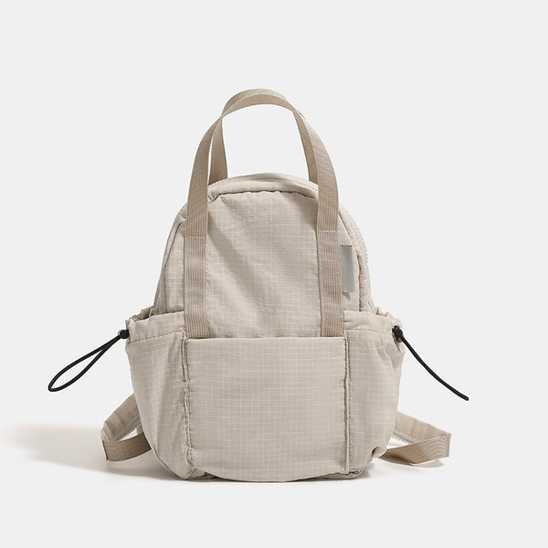 Mini rounded convertible backpack handbag in matte ripstop fabric with dual top handles, adjustable straps, and side, detail