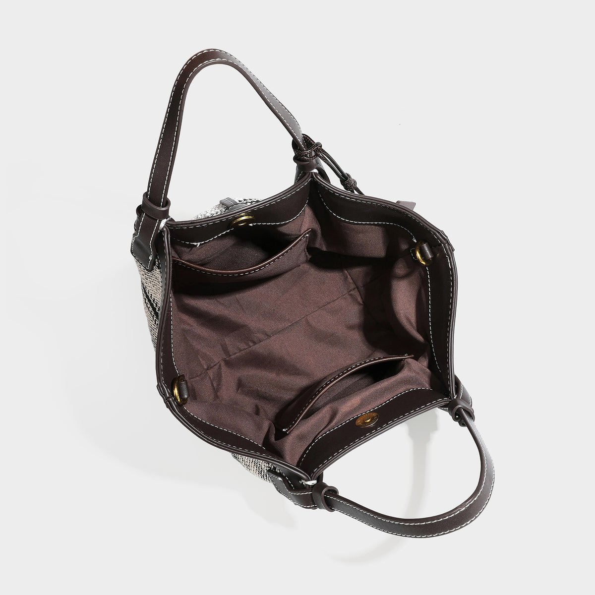 Schwarz-weiße gewebte Trapez-Tote-Bag mit dunklem Lederimitat-Besatz, weißen Kontrastnähten und zwei Henkeln, Detailansicht