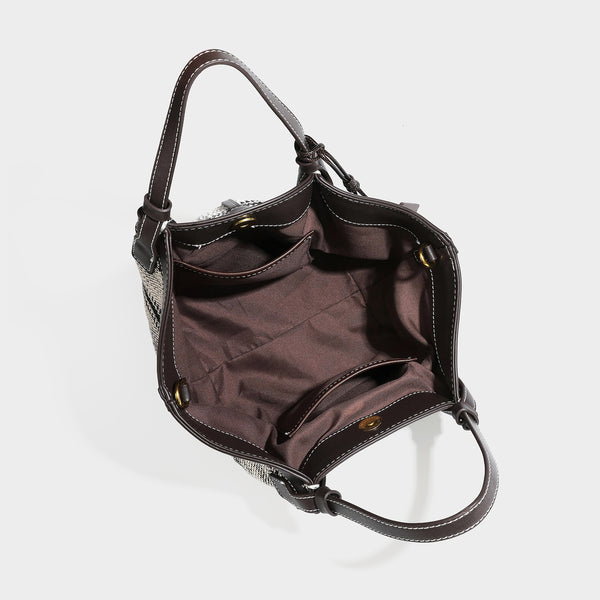 Schwarz-weiße gewebte Trapez-Tote-Bag mit dunklem Lederimitat-Besatz, weißen Kontrastnähten und zwei Henkeln, Detailansicht
