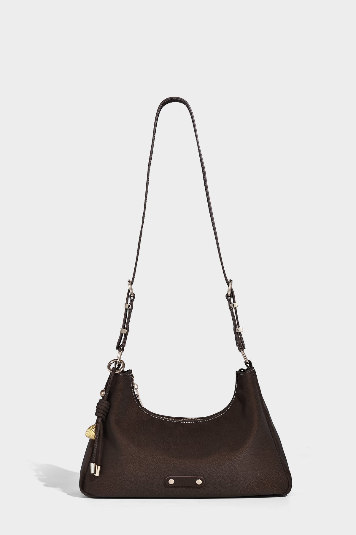 Crescent hobo shoulder bag in pebbled leather-look finish with top zipper, adjustable strap, gold-tone ring hardware, and