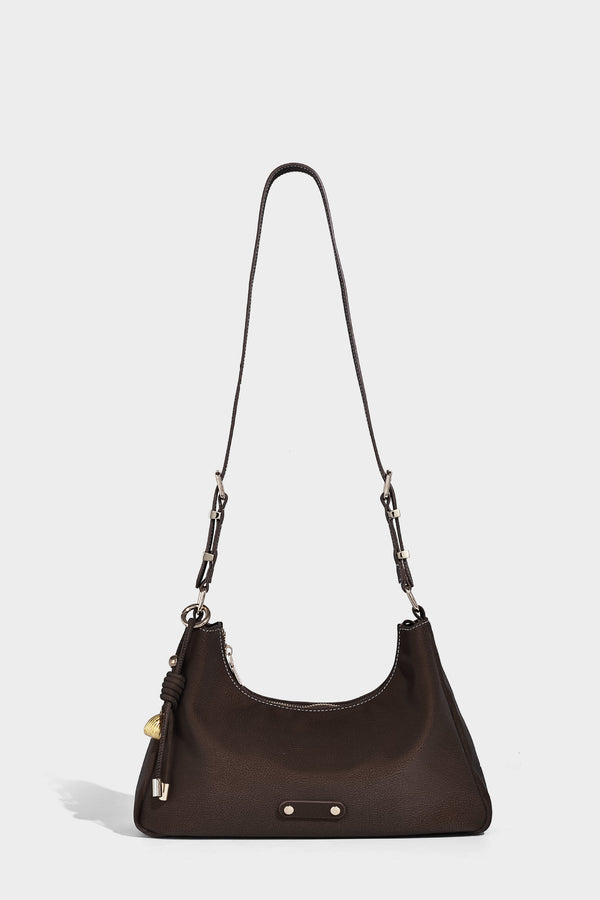 Crescent hobo shoulder bag in pebbled leather-look finish with top zipper, adjustable strap, gold-tone ring hardware, and