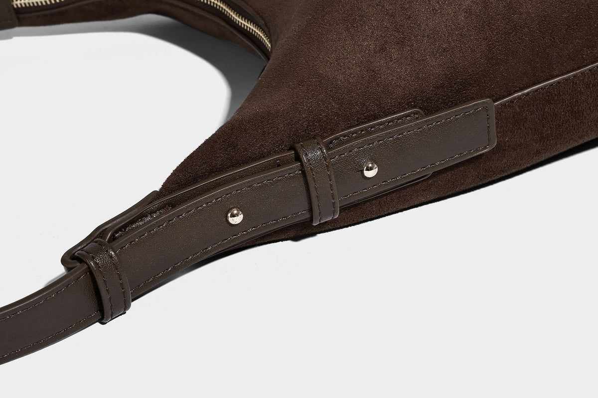 Dark brown suede-look hobo shoulder bag with top zip closure, adjustable strap, and small detachable mini pouch, detail view