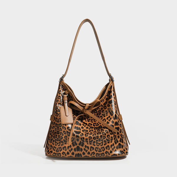 Slouchy leopard print shoulder hobo bag with black leather-look trim, tie-top closure, and single long strap, detail view 6