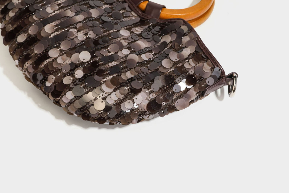 Small sequin half-moon handbag with circular wood-look ring handles and detachable leather-look shoulder strap, detail view