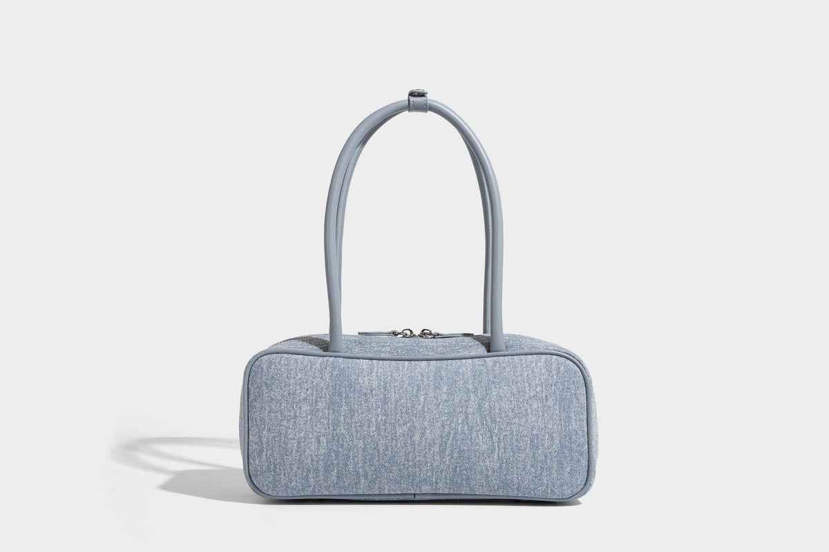 Small structured light blue denim-texture bowling bag with white floral bead embroidery, dual rounded top handles, and