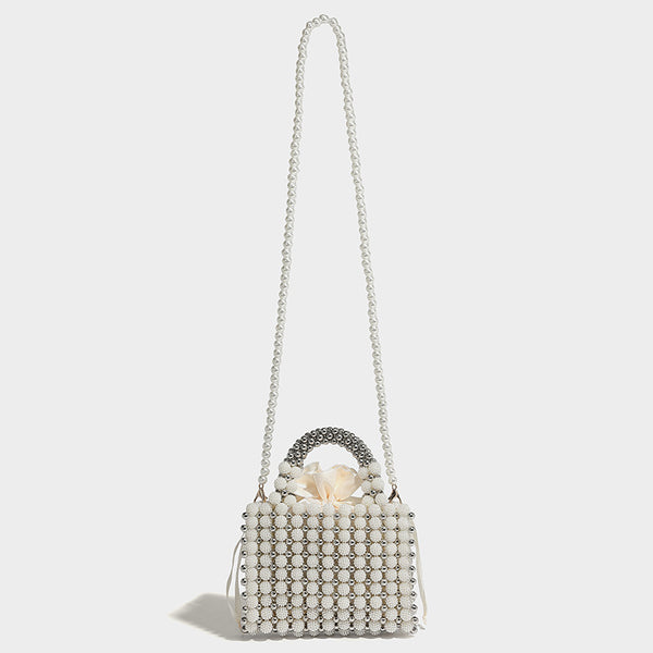 Small boxy pearl-bead mini top-handle bag with silver metallic bead accents, satin floral detail, and long beaded shoulder