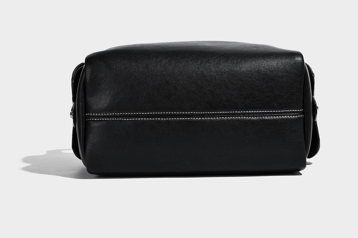 Small slouchy moto-style crossbody bag in smooth matte leather-look finish with white contrast stitching, silver-tone, detail