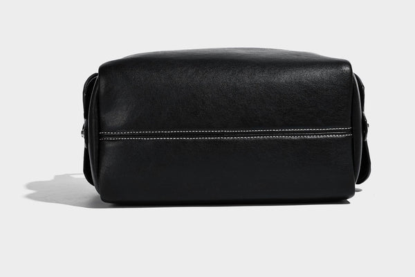 Small slouchy moto-style crossbody bag in smooth matte leather-look finish with white contrast stitching, silver-tone, detail