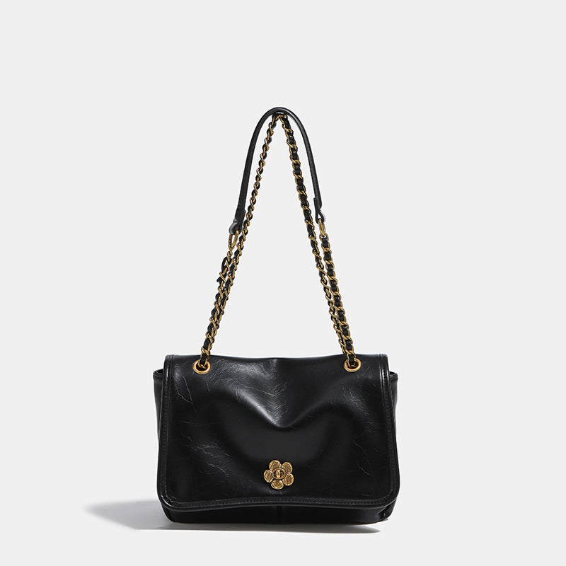 Structured flap shoulder bag with antique gold-tone chain strap and flower turn-lock clasp in crinkled leather-look finish